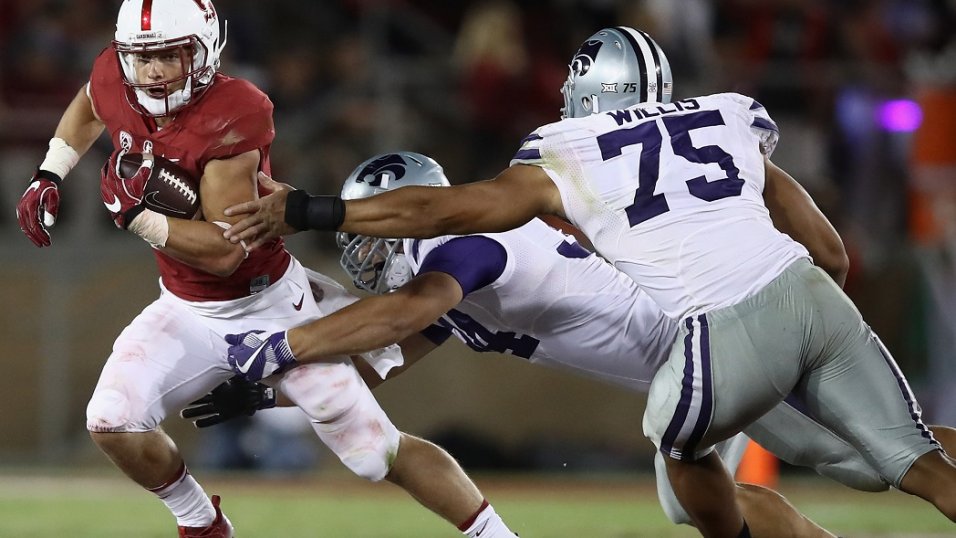 Christian McCaffrey Stanford Cardinal Unsigned White Jersey Leaps Over Line  vs. Arizona Wildcats Photograph