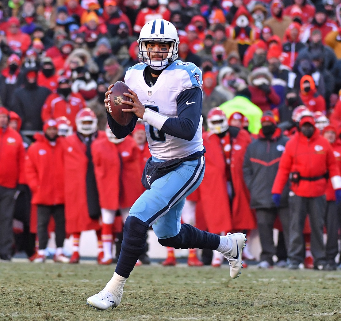 KANSAS CITY, MO - DECEMBER 18:  Quarterback Marcus Mariota #8 of the Tennessee Titans rolls out on a pass play against the…