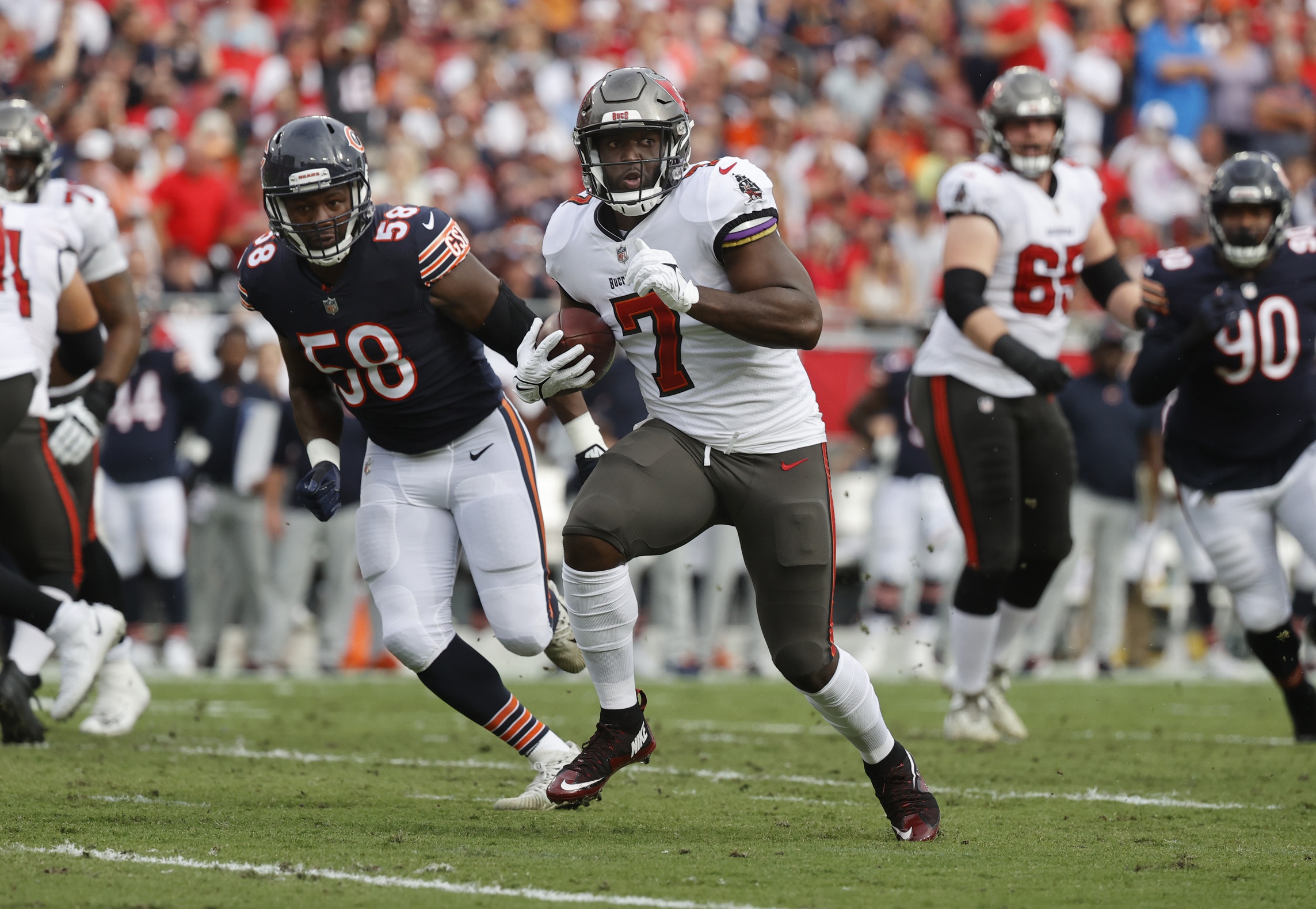 Chicago Bears running back Khalil Herbert (24) runs the ball past Raiders  cornerback Nate Hobbs …